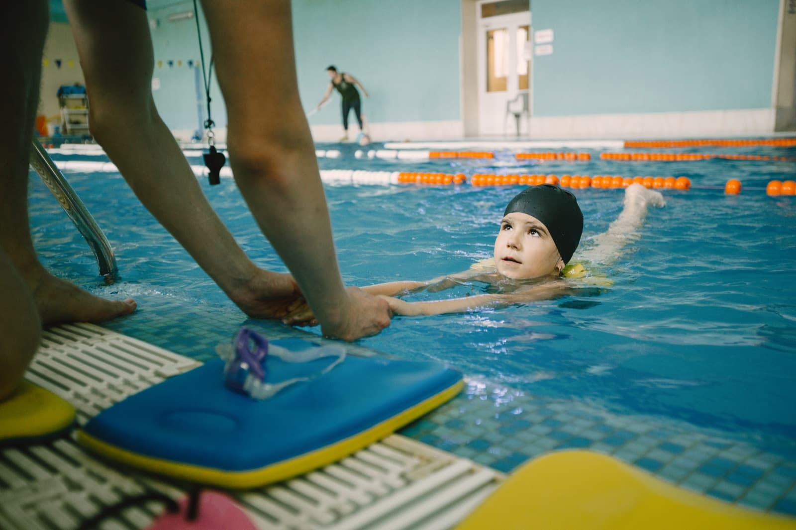 Pelatih mendampingi anak belajar olahraga di lapangan indoor
